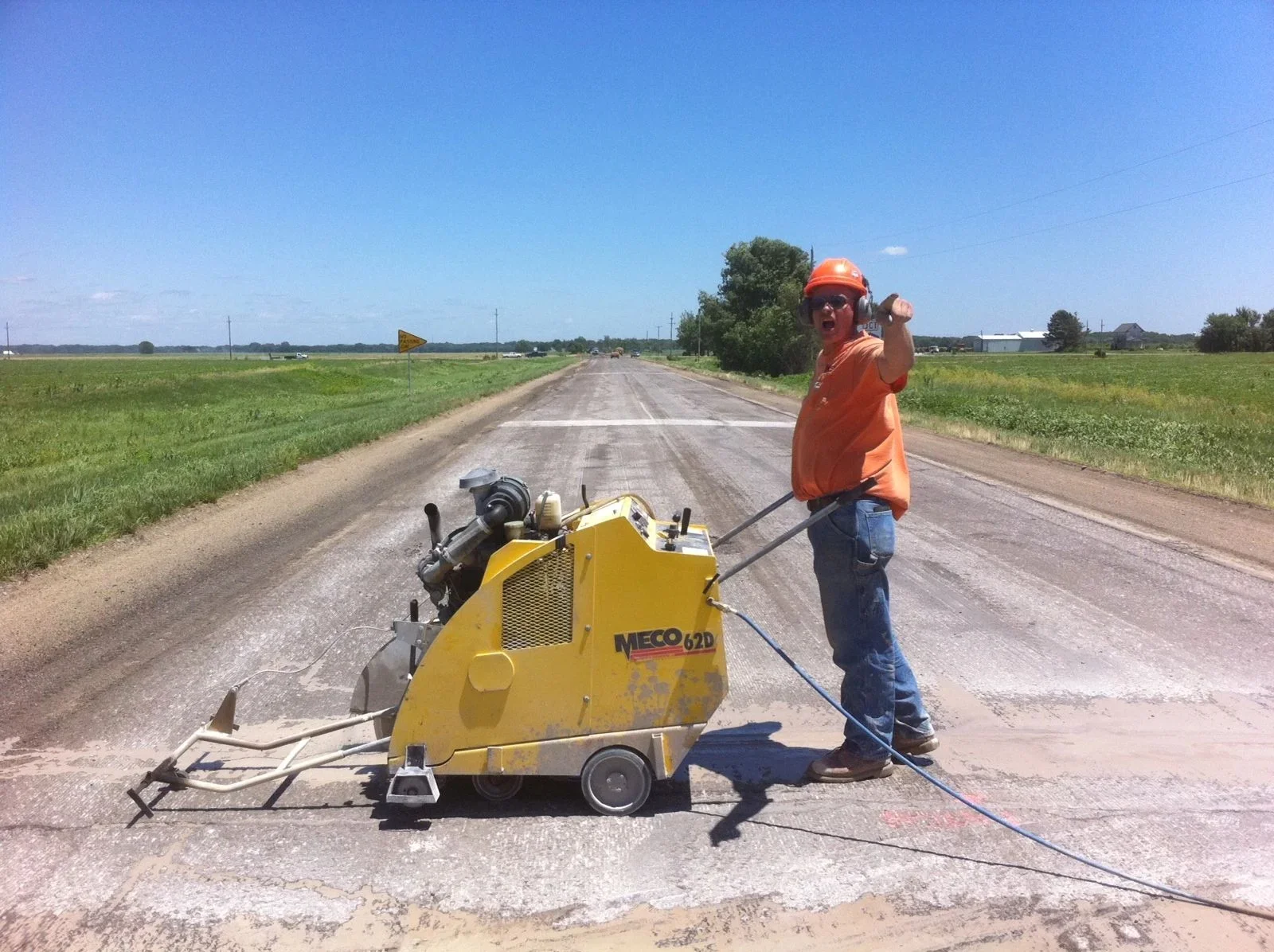 Worker operating handheld concrete saw